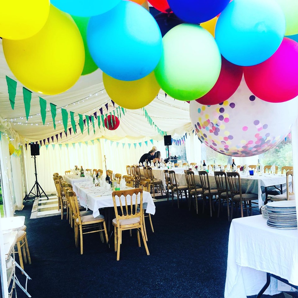 Chairs and tables with big balloons for a tent party